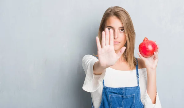 Vacker Ung Kvinna Över Grunge Grå Väggen Hålla Granatäpple Med — Stockfoto