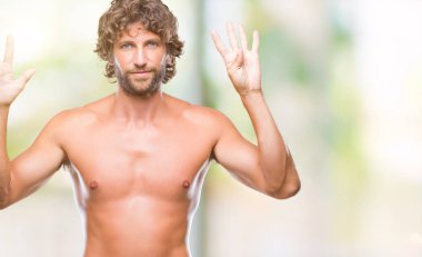 Yakışıklı İspanyol modeli adam seksi ve gömleksiz gösterilen ve parmakları ile işaret izole arka plan üzerinde numara 9 kendinden emin ve mutlu gülümseyerek süre.