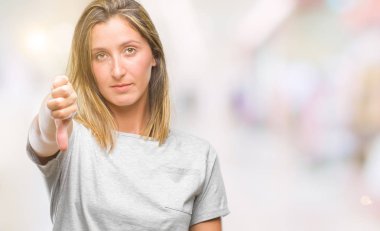 Genç güzel kadın yüzünden mutsuz ve kızgın ret gösterilen ve başparmak aşağı hareketi ile negatif seyir izole arka plan. Kötü ifade.