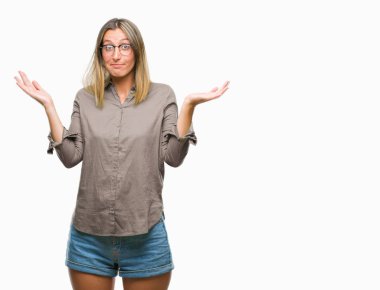 İzole arka plan clueless ve şaşkın bir ifadeyle kollar ve eller kaldırdı genç güzel kadın. Şüphe kavramı.