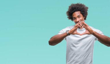 Kalp simgesi ve elleriyle şekil gösterilen aşık gülümseyen izole arka plan üzerinde Afro Amerikalı adam. Romantik kavramı.