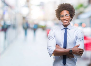 Afro Amerikalı iş adamı izole arka plan mutlu yüz ile gülümseyen üzerinde gözlük takan silah kameraya bakarak geçti. Olumlu bir kişi.