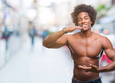 Çıplak vücut ile büyük ve büyük boy işaret, ölçü birimi sembol gösteren el eller izole arka plan üzerinde gösterilen Afro Amerikalı gömleksiz adam. Kameraya bakarak gülümsüyordu. Ölçüm kavramı.