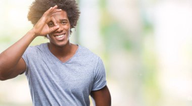 Afro Amerikalı adam gülümsüyor, parmakları ile mutlu yüz üzerinden seyir göz el ile ok jest yapıyor izole arka plan üzerinde.