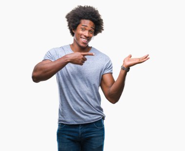 İzole edilmiş arka planda yaşayan Afro-Amerikalı adam kameraya hayret ediyor ve gülümsüyor..