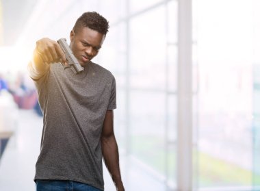 Elinde bir silah kendine güvenen bir ifade ile acımak yüz ciddi düşünüyorum genç Afro-Amerikan adam