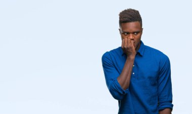 Genç Afro-Amerikan adam stresli ve gergin ile izole arka plan üzerinde tırnak ısırma dudaklarından eller. Anksiyete sorunu.