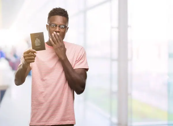 Młody Człowiek African American Posiadający Paszport Kanadyjski Pokrywa Usta Ręką — Zdjęcie stockowe