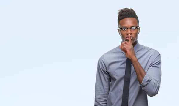 Young african american business man over isolated background asking to be quiet with finger on lips. Silence and secret concept.