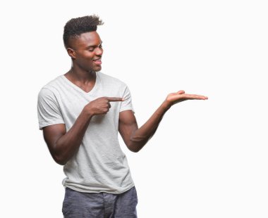 Genç Afro-Amerikan adam üzerinden hayran ve el ile sunulması ve parmak ile işaret ederken kameraya gülümseyen izole arka plan.