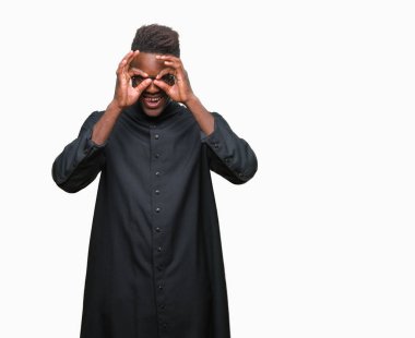 Genç Afro-Amerikan rahip adam izole arka plan, dilini parmaklarının arasından baktığını yapışmasını dürbün gibi ok jest yapıyor. Deli ifade.