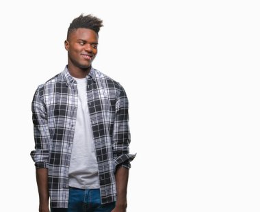 Afrikalı-Amerikalı genç uzak tarafına yüzünde, doğal ifade gülümseme ile seyir izole arka plan üzerinde. Kendine güvenen gülüyor.