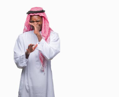 İzole arka plan kokulu üzerinde geleneksel keffiyeh pis ve iğrenç bir şey, dayanılmaz koku, holding nefes parmak ile burun üzerinde giyen genç Arapça Afrika adam. Kötü kokuyor kavramı.