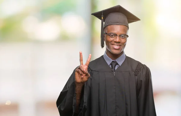 若いが示す分離の背景にアフリカ系アメリカ人を卒業し 自信を持って 幸せな笑みを浮かべている間 つ番号を指で上向き — ストック写真
