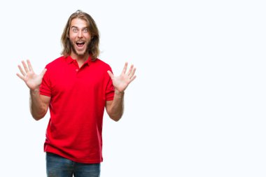 Yakışıklı delikanlı deli kutluyor ve silah ile başarı için heyecanlı çığlık kaldırdı ve açık gözleri hayret izole arka plan üzerinde uzun saçlı. Kazanan kavramı