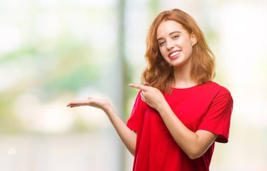 Genç güzel kadın üzerinden hayran ve el ile sunulması ve parmak ile işaret ederken kameraya gülümseyen izole arka plan.