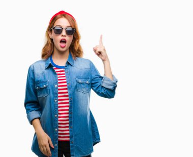 Genç güzel kadın yüzünden izole arka plan başarılı fikirle parmak işaret güneş gözlüğü takıyor. Çıktıktan ve mutlu. Bir numara.