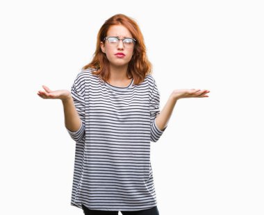 İzole arka plan gözlük clueless ve şaşkın bir ifadeyle kollar ve eller kaldırdı giyen genç güzel kadın. Şüphe kavramı.