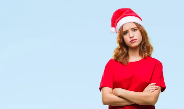 年轻美丽的女人在孤立的背景下戴着圣诞帽怀疑和紧张 不赞成的表情与交叉的武器 消极的人 — 图库照片