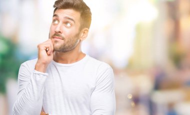 Yakışıklı delikanlı çene düşünme hakkında soru, dalgın ifade üzerine el ile izole arka plan üzerinde. Düşünceli yüzüyle gülümsüyor. Şüphe kavramı.