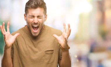 Genç yakışıklı adam kızgın ve silah ile başarı için deli kutluyor izole arka plan üzerinde kaldırdı ve heyecanlı çığlık gözler kapalı. Kazanan kavramı