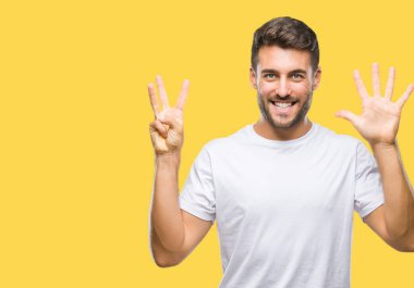 Yakışıklı delikanlı gösterilen ve parmakları ile işaret izole arka plan üzerinde kendinden emin ve mutlu gülümseyerek süre sekiz numara.