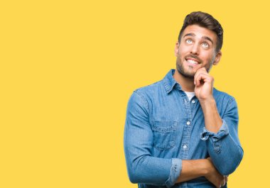 Yakışıklı delikanlı çene düşünme hakkında soru, dalgın ifade üzerine el ile izole arka plan üzerinde. Düşünceli yüzüyle gülümsüyor. Şüphe kavramı.