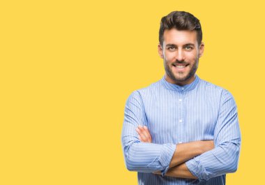 İzole arka plan mutlu yüz çapraz silah kameraya bakarak ile gülümseyen genç yakışıklı adam. Olumlu bir kişi.