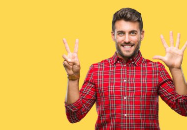 Yakışıklı delikanlı gösterilen ve parmakları ile işaret izole arka plan üzerinde kendinden emin ve mutlu gülümseyerek süre yedi numara.