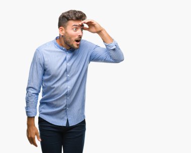 Yakışıklı delikanlı izole arka plan çok mutlu ve gülümseyen uzakta el ile üzerine kafa seyir üzerinde. Arama kavramı.