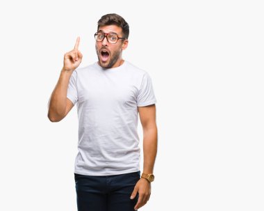 Başarılı fikirle izole arka plan işaret parmağı üzerinde gözlük takan yakışıklı delikanlı. Çıktıktan ve mutlu. Bir numara.