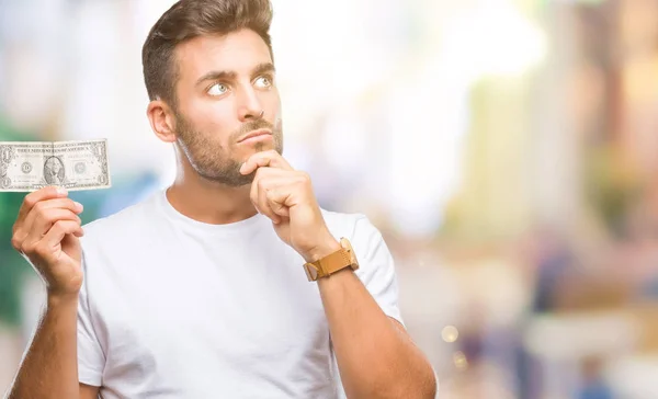 Joven Hombre Guapo Sosteniendo Dólares Sobre Fondo Aislado Cara Seria —  Fotos de Stock