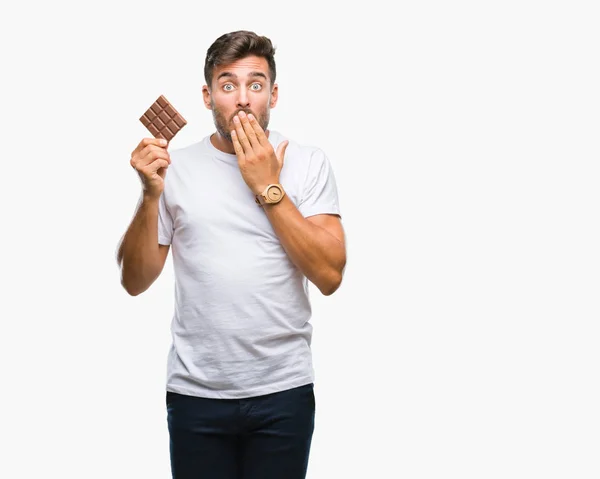 Όμορφος Νεαρός Τρώει Σοκολάτα Πάνω Από Απομονωμένες Φόντο Κάλυμμα Στόματος — Φωτογραφία Αρχείου