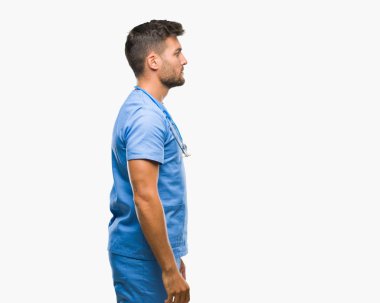 Genç yakışıklı Doktor cerrah adam izole arka tarafına, seyir üzerinde dinlenmek doğal yüz emin gülümseme ile pozuyla profil.
