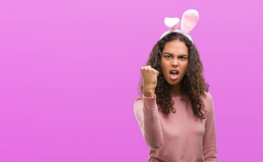 Öfke, çılgın ve yükseltilmiş eliyle diye bağıran ile rahatsız ve hayal kırıklığına uğramış öfke kavramı bağırarak genç İspanyol kadın giyiyor Paskalya bunny kulaklar