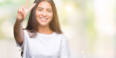 Genç güzel Arap kadın parmaklarını zafer işareti yaparken gösterilen kamera seyir gülümseyen izole arka plan yüzünden. İki numaralı.