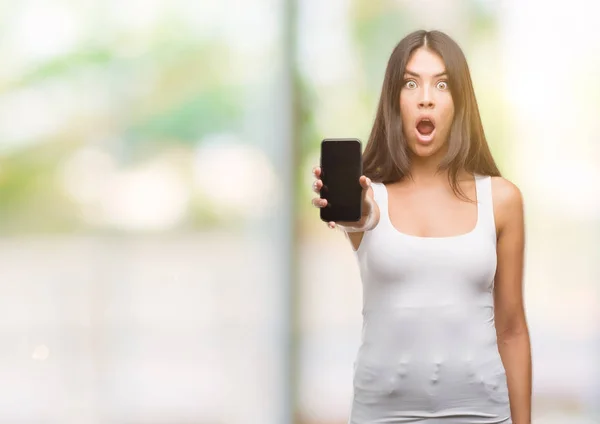 Joven Hispano Hermoso Mostrando Teléfono Inteligente Asustado Shock Con Una — Foto de Stock