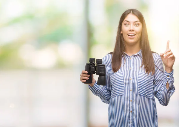 Young Hispanic Woman Holding Binoculars Surprised Idea Question Pointing Finger — Stock Photo, Image