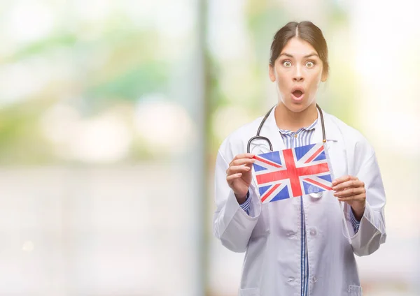 Joven Doctora Hispana Sosteniendo Bandera Del Reino Unido Asustada Shock —  Fotos de Stock