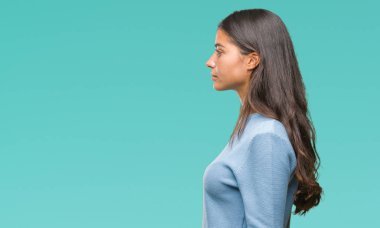 Genç güzel Arap kadın giyiyor kış kazak izole arka tarafına, seyir üzerinde dinlenmek doğal yüz emin gülümseme ile pozuyla profili.