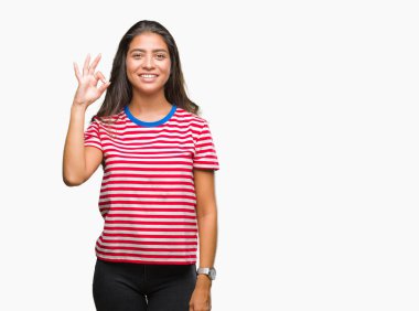 Gülümseyen izole arka plan üzerinde genç güzel Arap kadın el ve parmaklar ok işaretiyle yapıyor olumlu. Başarılı ifade.