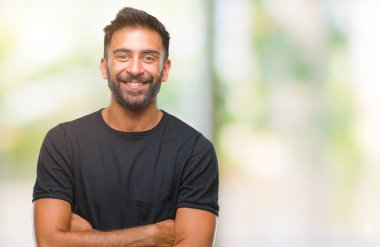 Kameraya bakarak çapraz silah ile gülümseyen izole arka plan mutlu yüz yetişkin İspanyol adam. Olumlu bir kişi.