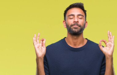 İzole arka plan yetişkin İspanyol adam rahatla ve gülümseyen gözlerle kapalı parmak jestle meditasyon yapıyor. Yoga kavramı.