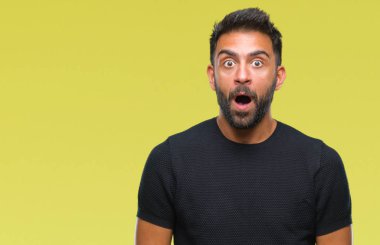 Yetişkin İspanyol adam korkuyor ve şok sürpriz ifade ile izole arka plan üzerinde korku ve yüz heyecanlı.