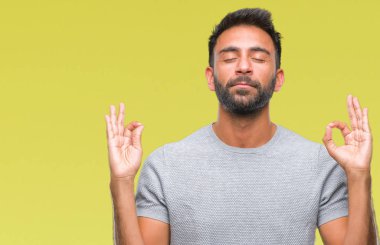 İzole arka plan yetişkin İspanyol adam rahatla ve gülümseyen gözlerle kapalı parmak jestle meditasyon yapıyor. Yoga kavramı.