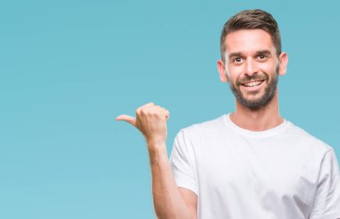 Yakışıklı delikanlı arıyor ve başparmak yanında yukarıyı mutlu yüz ile gülümseyen izole arka plan üzerinde.