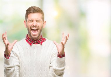 Yakışıklı delikanlı deli ve silah ile başarı için deli kutluyor izole arka plan üzerinde kış kazak giyen kaldırdı ve heyecanlı çığlık gözler kapalı. Kazanan kavramı