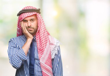 Düşünme izole arka plan bakmaktan keffiyeh giyen genç yakışıklı Arap iş adamı yorgun ve sıkılmış çapraz silah depresyon sorunları ile.