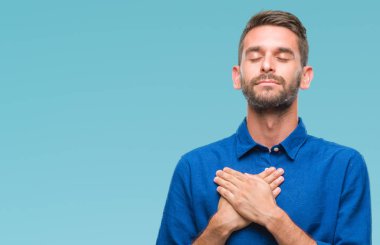 Yakışıklı delikanlı ile gülümseyen izole arka plan üzerinde kapalı gözler ve yüzünde minnettar jest ile göğüs üzerinde eller. Sağlık kavramı.