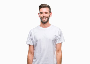 Genç yakışıklı adam seksi bir ifadeyle, neşeli ve mutlu yüzünü kameraya bakarak göz kırpıyor izole arka plan üzerinde.